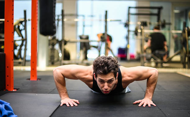 istock Determined young man performing push-ups at the gym 2191609367