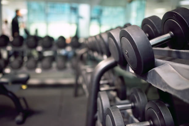 istock Dumbbells arranged on rack in modern gym with blurred background 2191609701
