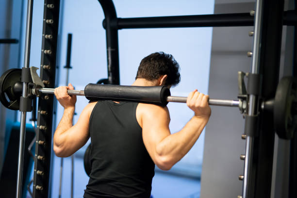 istock Bodybuilder lifting weights in the gym performing squats 2191609739