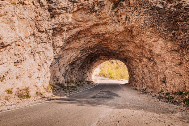 istock Scenic route navigating through a tunnel carved into a natural rock formation, creating a picturesque passage 2191610177