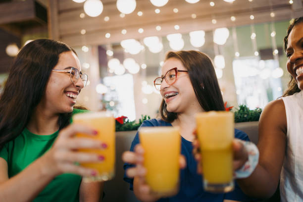 Female friends drinking orange juice