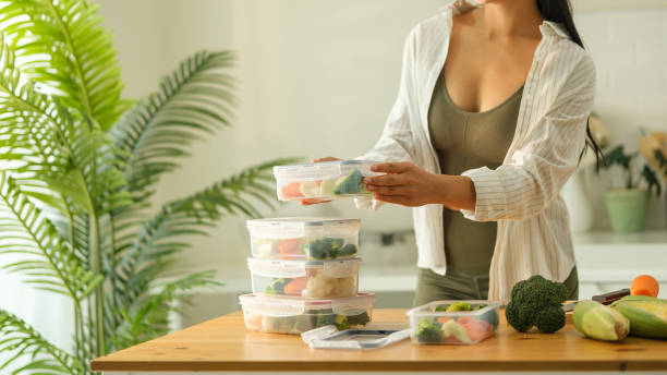 istock Attractive woman arranging her meal prep containers on the kitchen counter, ready for a week of healthy eating. Healthy lifestyle and nutrition concept. 2191620336