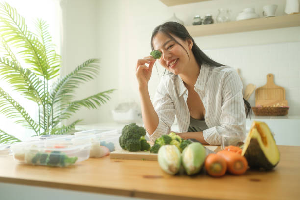 istock Woman smiles warmly while preparing fresh vegetables in her kitchen. 2191620587