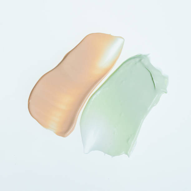 istock Light green and orange blobs of lotion with a soft on a plain white background 2191627313