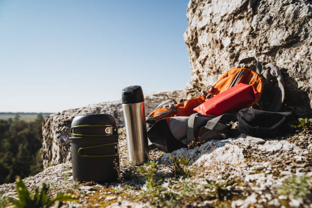 istock There is a backpack and a thermos placed on top of a large rock 2191629236