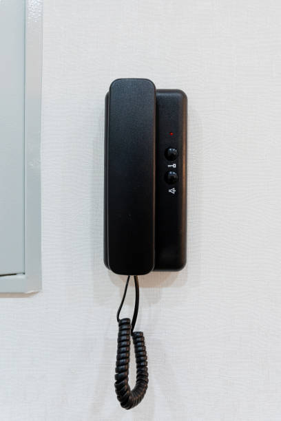 istock A classic black telephone against a bright white wall creates a striking contrast, enhancing the rooms decor and making it more inviting and visually pleasing to those who enter 2191638597