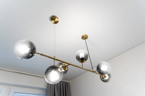 istock A stunningly beautiful chandelier is elegantly hanging from the ceiling in a spacious room, casting a warm and inviting glow while enhancing the overall ambiance of the space 2191638602