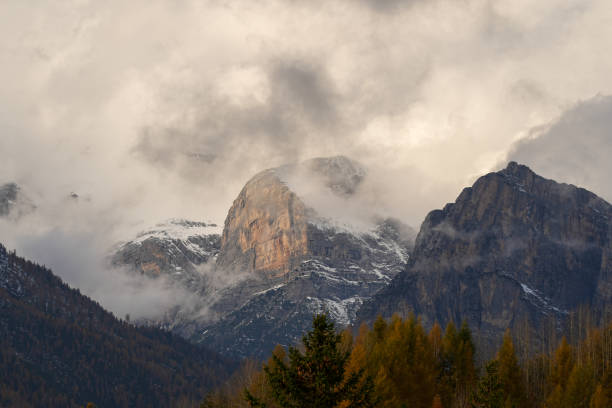 Jagged mountain peaks emerging through mist and clouds. Serene landscape capturing the beauty of nature.