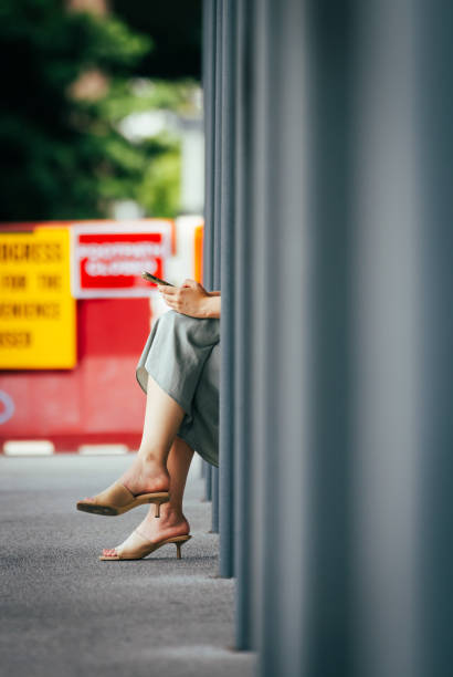 Business woman is waiting to bus at bus station.\nNewton - Singapore.