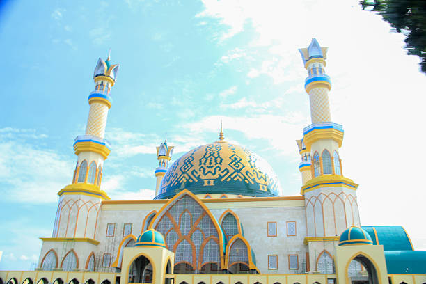istock A vibrant mosque with a striking blue and gold dome adorned with geometric patterns, flanked by ornate minarets under a bright blue sky. The architecture blends traditional Islamic elements with modern design. 2191645244