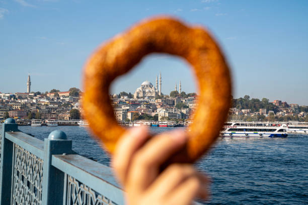 Hand holding Turkish bagel (simit), in stanbul