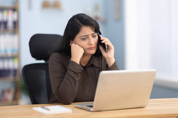 istock Worried businesswoman using laptop and using mobile phone working in office stock photo 2191646708