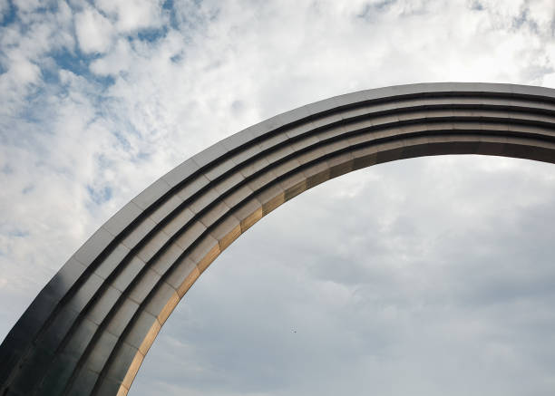 istock Looking up at metal arch in cloudy sky. 2191647236