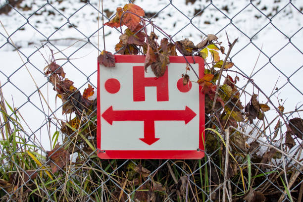 Hydrant placement sign with triple directions on a wire fence with snow