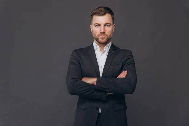 istock Caucasian millennial businessman isolated on gray studio background posing, satisfied successful man in formal suit standing with arms crossed 2191648938