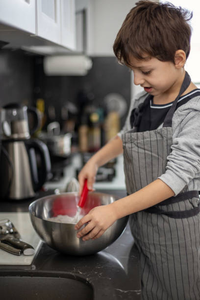 istock Young Chef in Action: A Boy Mixing Ingredients in the Kitchen 2191649428