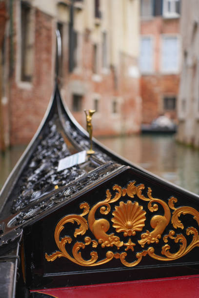 Elegant gondola navigating a narrow canal between ancient brick buildings. Scenic view of Venice’s historic architecture. Iconic imagery of Italian waterways