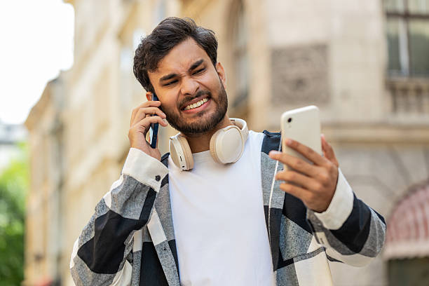 istock Stressed Indian man talking screaming on mobile phones having conflict quarrel complaint on street 2191655942