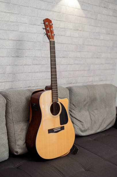 istock Beautiful six-string acoustic guitar, wood body, on sofa in studio 2191656443