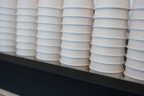 White plastic used cup on blue paper background.