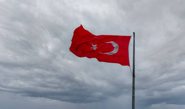 istock Red Turkish flag with white star and crescent waving in the wind against a dramatic cloudy sky 2191657799