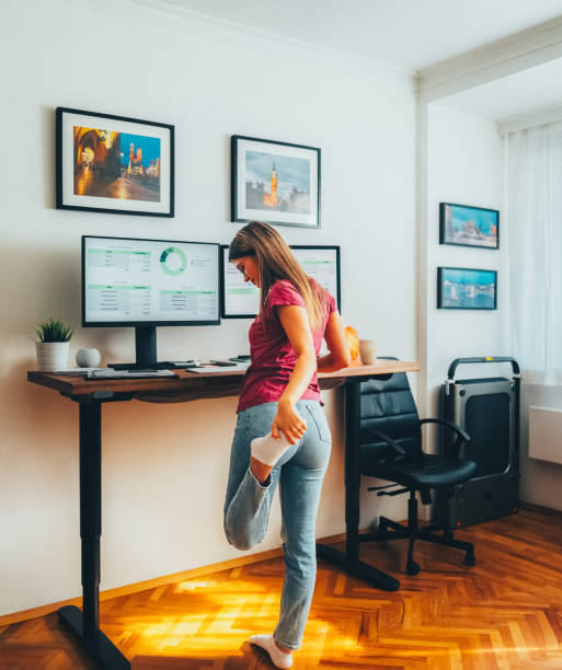 istock Young woman working at standing desk 2191659972