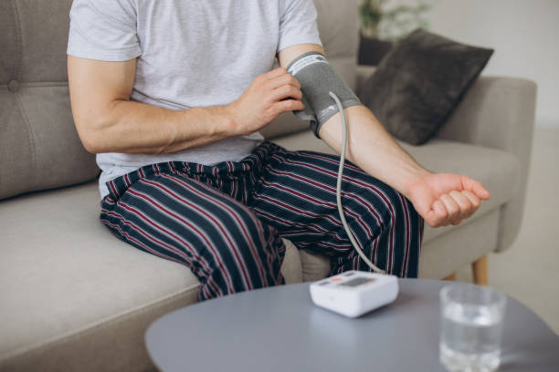 istock Close-up male sitting on couch at home, checking blood pressure. Man using modern tonometer, experiencing hypertension caused by stress, copy space 2191662290