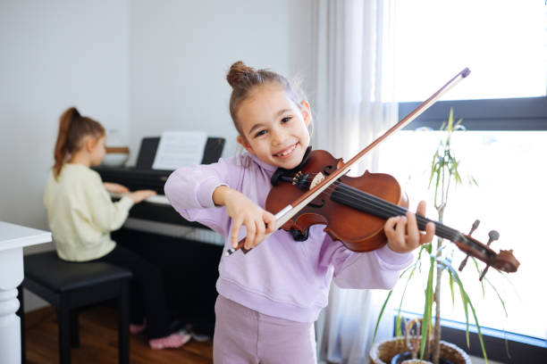 istock Two sisters having fun practicing piano and violin together 2191663150