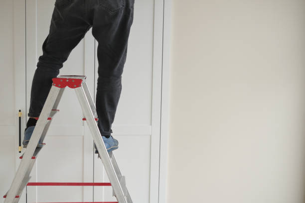 istock A person is standing safely on a ladder while working on a home improvement project 2191663417