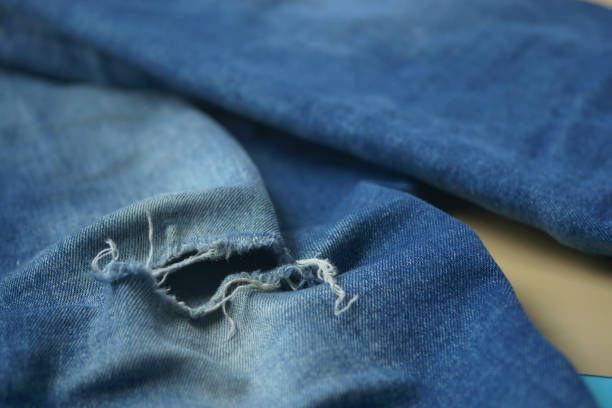 istock blue jean texture with a hole and ripped threads showing 2191663890