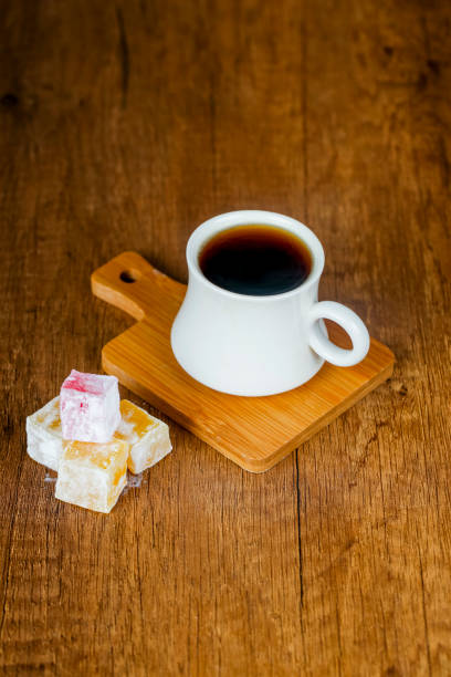 istock Coffee cup on wooden board accompanied by colorful sweets 2191664029