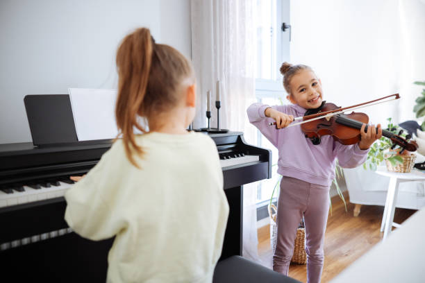 istock Two sisters having fun practicing piano and violin together 2191664104