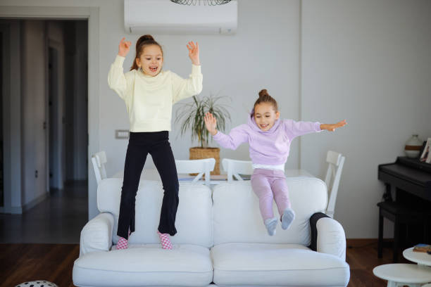 istock Happy girls jumping on the sofa 2191664211