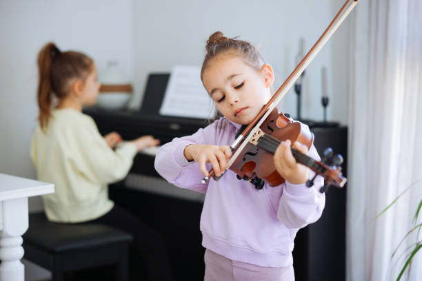 istock Two sisters having fun practicing piano and violin together 2191664338