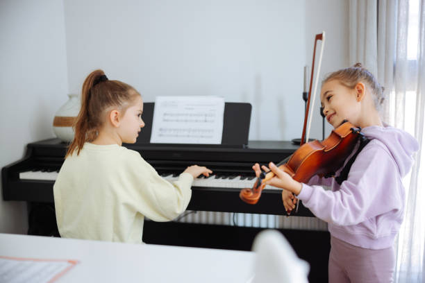 istock Two sisters having fun practicing piano and violin together 2191664402