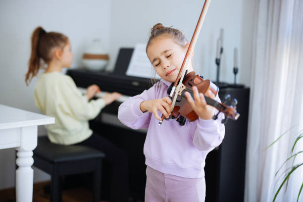 istock Two sisters having fun practicing piano and violin together 2191664651