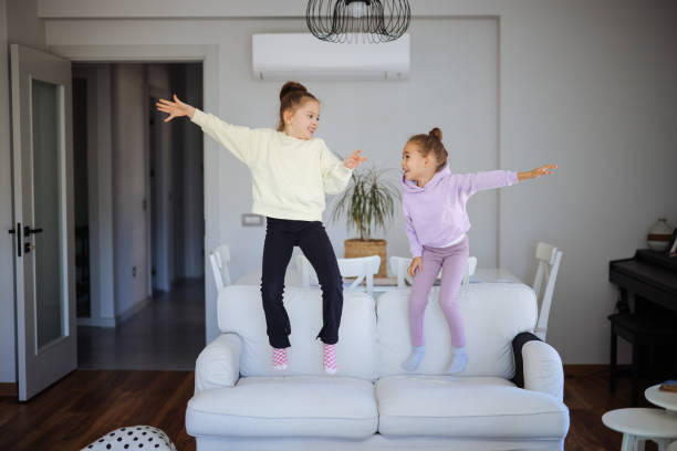 istock Happy girls jumping on the sofa 2191664684