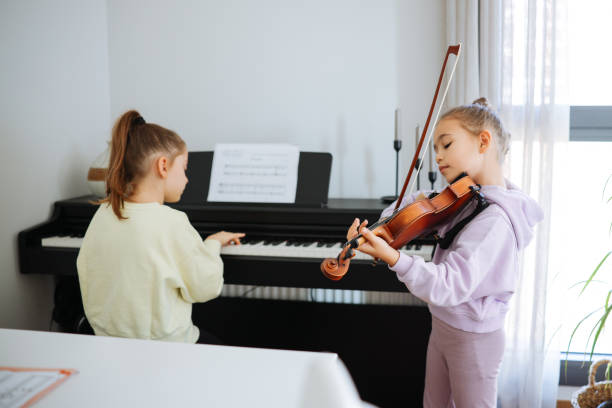 istock Two sisters having fun practicing piano and violin together 2191664740