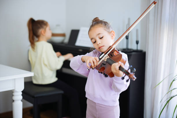 istock Two sisters having fun practicing piano and violin together 2191664869
