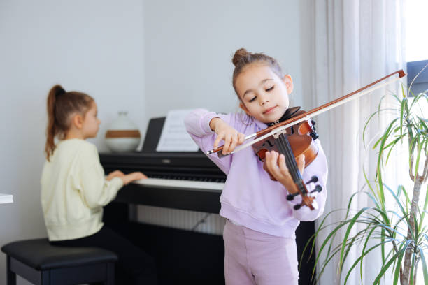 istock Two sisters having fun practicing piano and violin together 2191665868