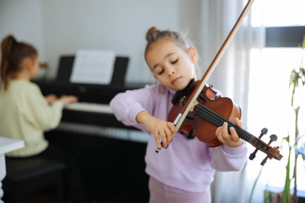 istock Two sisters having fun practicing piano and violin together 2191666019
