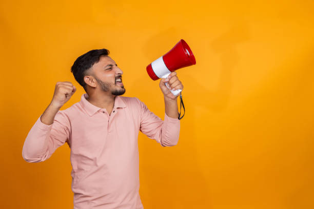 istock indian man making announcement on megaphone on isolated background 2191672120