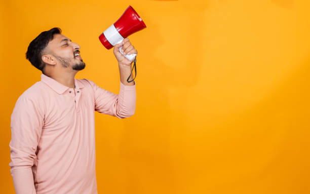 istock indian man making announcement on megaphone on isolated background 2191672151