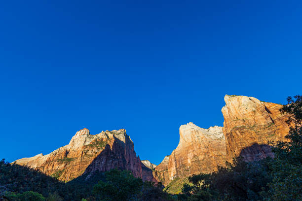 First rays of sunlight on the majestic sandstone formations at Zion National Park on a cool autumn morning.