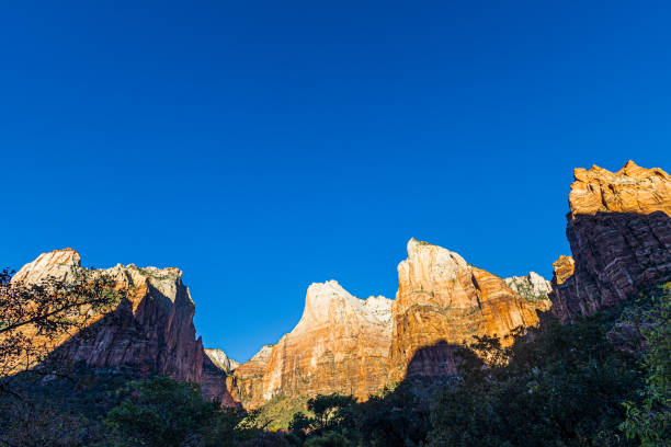 First rays of sunlight on the majestic sandstone formations at Zion National Park on a cool autumn morning.