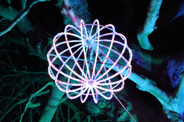 istock Christmas lights at night - large round bauble hanging from a tree in a park 2191673347