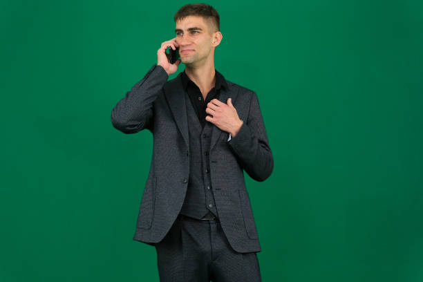 An Indian man looks tense and frustrated while talking on his mobile phone in a modern office setting, showing signs of anger and stress. High quality photo