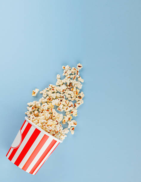 istock Classic red striped popcorn cardboard cup on blue background 2191676584
