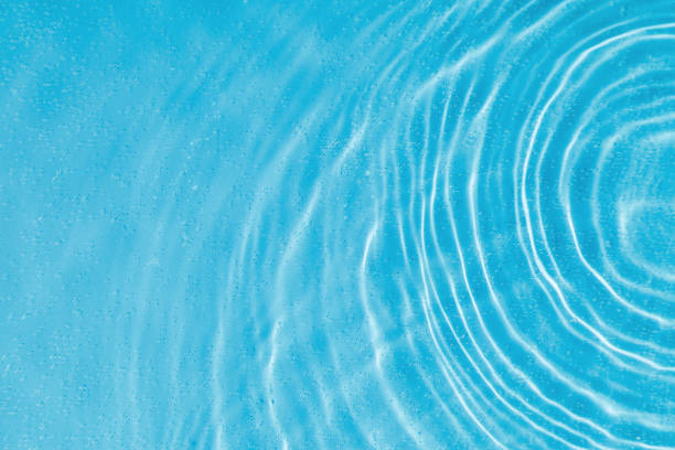istock drops on water with circles on a blue background 2191676655