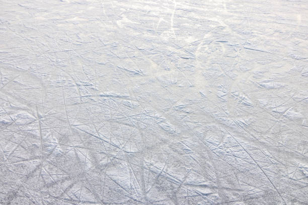 Close-Up Of Skating Rink Surface With Visible Ice Skate Marks Outdoor skating rink showing signs of extended use with numerous skate marks across its icy surface, capturing the dynamic atmosphere of recreational activities in a winter wonderland setting. scuff marks photos stock pictures, royalty-free photos & images